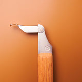 A close-up of the premium 215mm Red Oak handle of the KAKURI saw, showing the unique, snag-free blade latch.